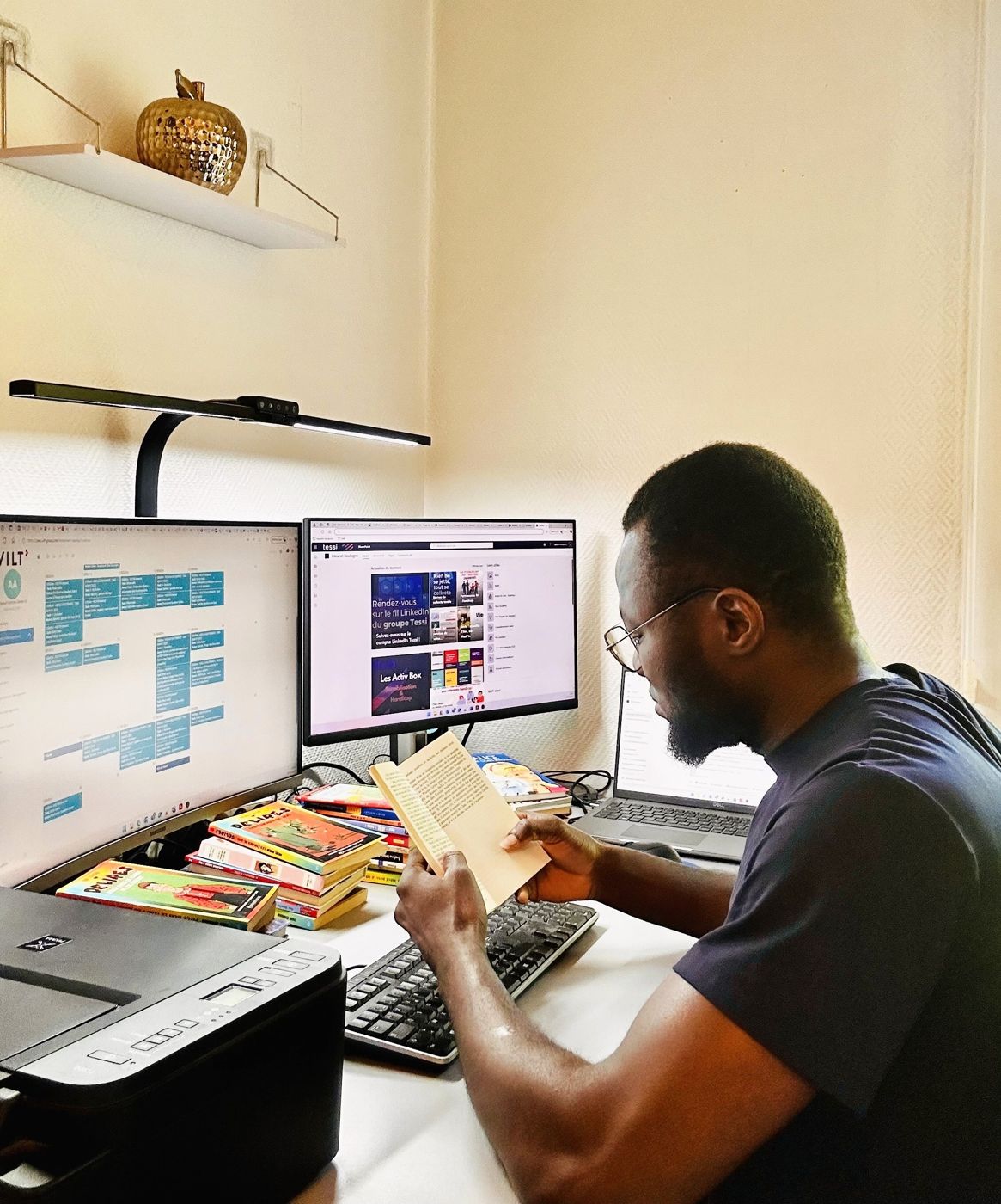 Espace de travail d'Abiona Ali avec double écran et documentation technique